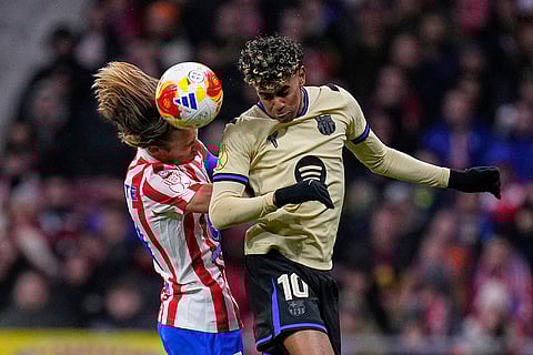 Atletico Madrid's Marcos Llorente, left and Barcelona's Lamine Yamal challenge for the ball during the Copa del Rey semifinal first leg soccer match between Atletico Madrid and Barcelona in Madrid, Spain.