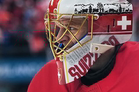 Switzerland's goalkeeper Leonardo Genoni grimaces during a preliminary round match of men's ice hockey between Switzerland and France at the 2026 Winter Olympics, in Milan, Italy.