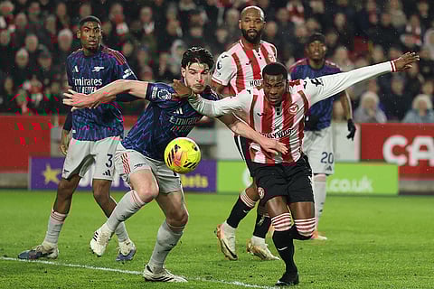 Arsenal's Declan Rice, left, and Brentford's Dango Ouattara fight for the ball during the English Premier League soccer match between Brentford and Arsenal in London.