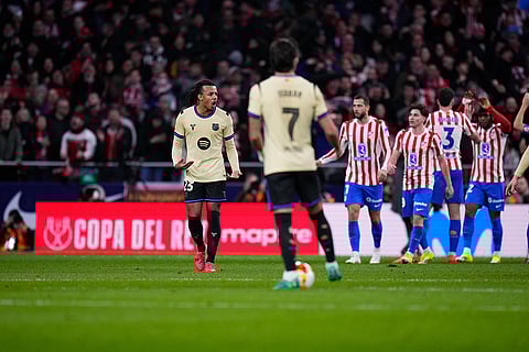 Barcelona's Jules Kounde, left, reacts after Atletico Madrid's Ademola Lookman scored his side's third goal during the Copa del Rey semifinal first leg soccer match between Atletico Madrid and Barcelona in Madrid, Spain.