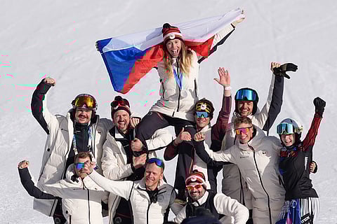 Silver medalist Czechia's Eva Adamczykova celebrates with team members after the women's snowboard cross finals at the 2026 Winter Olympics, in Livigno, Italy.