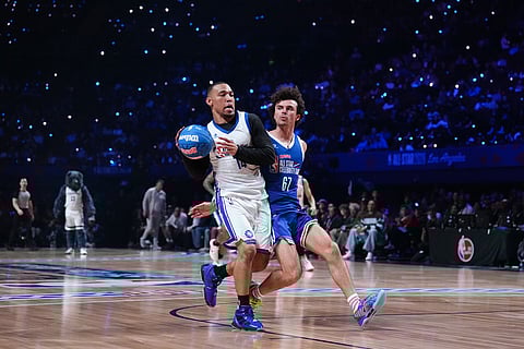 Amon-Ra St. Brown, left, is defended by Nicolas Vansteenberghe during an NBA basketball's All-Star Celebrity Game in Inglewood, Calif.