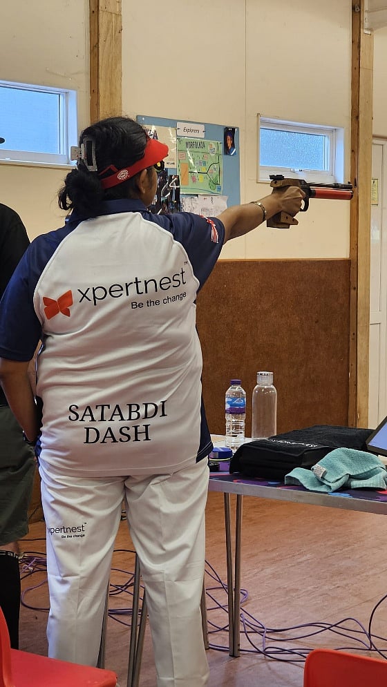Satabdi Dash aiming an air pistol in her Xpertnest sports uniform