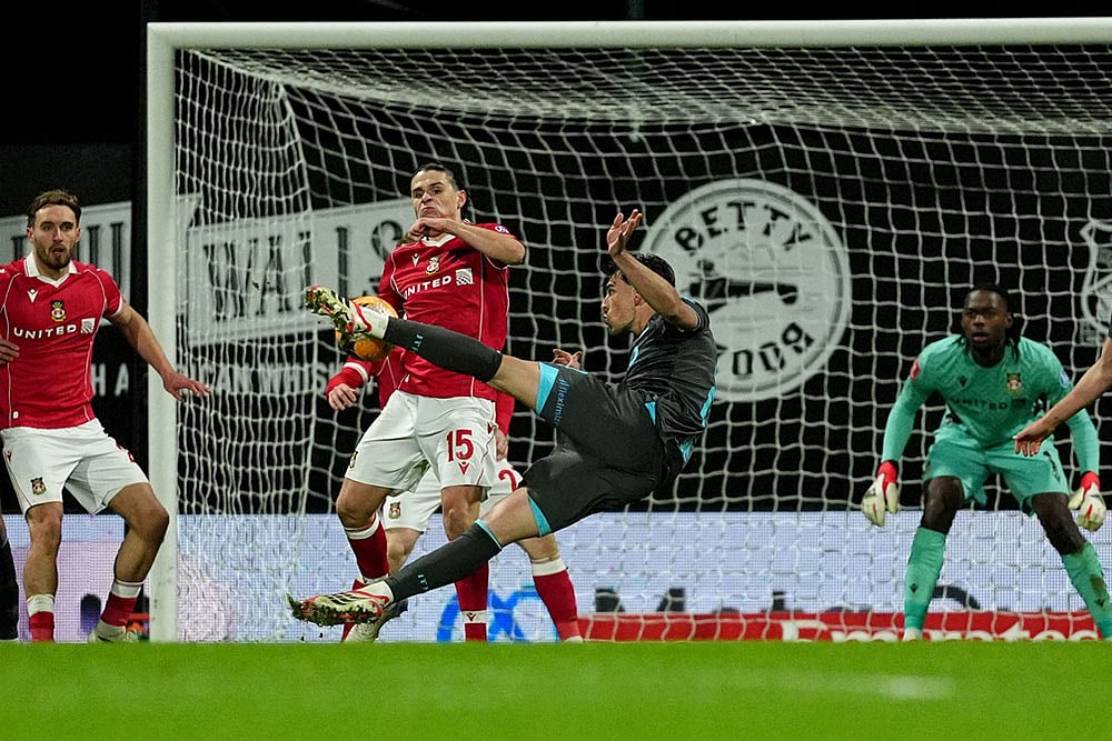 | Photo: Martin Rickett/PA via AP : Ipswich Town's Jacob Greaves, front, has a shot at goal blocked by Wrexham's George Dobson (15) during an English FA Cup fourth round soccer in Wrexham, Wales.