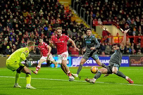 Ipswich Town's Jacob Greaves, right, blocks a cross as Wrexham's Sam Smith (28) looks on  during an English FA Cup fourth round soccer in Wrexham, Wales.