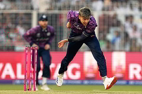 Scotland's Bradley Currie bowls a delivery during the T20 World Cup cricket match between England and Scotland in Kolkata, India.