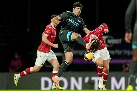 Ipswich Town's Ivan Azon, center,and Wrexham's Callum Doyle battle for the ball  during an English FA Cup fourth round soccer in Wrexham, Wales. 
