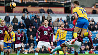 | Photo: PA/Richard Sellers via AP : Mansfield Town's Rhys Oates, top, scores during the English FA Cup fourth round soccer match between Burnley and Mansfield Town in Burnley, England, Saturday Feb. 14, 2026.