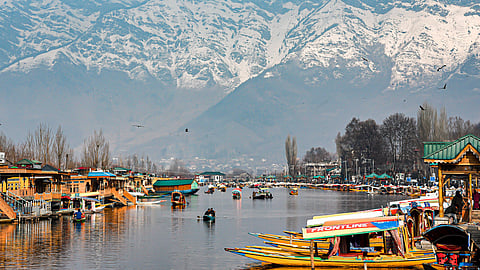 Tourists enjoy Shikara rides on the Dal Lake amid snow-covered mountains, in Srinagar