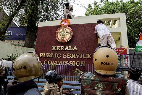 Youth Congress activists place a wreath atop the Kerala Public Service Commission office gate during a protest against the alleged denial of appointments to rank holders, as police personnel stand guard, in Thiruvananthapuram.