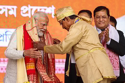 Prime Minister Narendra Modi being felicitated during a BJP workers' meeting, in Guwahati. Union Minister Sarbananda Sonowal is also seen. 