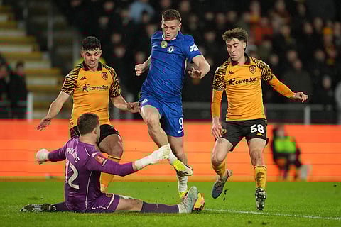 Chelsea's Liam Delap passes the ball in front of Hull City's goalkeeper Dillon Phillips during the English FA Cup fourth round soccer match between Hull City and Chelsea in Hull, England.
