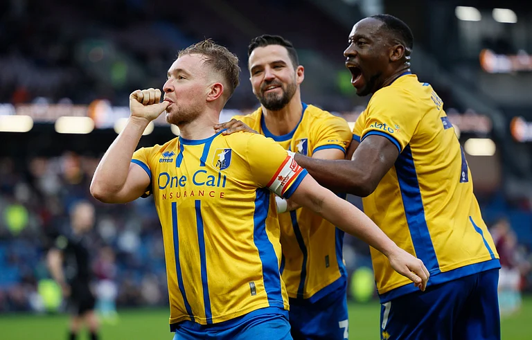Mansfield Town's Louis Reed, left, celebrates scoring during the English FA Cup fourth round soccer match between Burnley and Mansfield Town in Burnley, England, Saturday Feb. 14, 2026. - | Photo: PA/Richard Sellers via AP