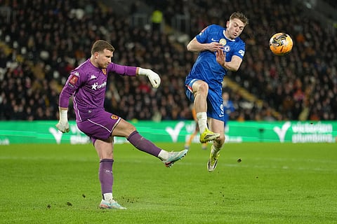 Hull City's goalkeeper Dillon Phillips clears the ball in front of Chelsea's Liam Delap during the English FA Cup fourth round soccer match between Hull City and Chelsea in Hull, England.