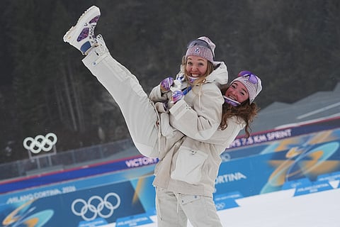 Bronze medalist Lou Jeanmonnot, of France, lifts silver medalist Oceane Michelon, of France, after the women's 7.5-kilometer sprint biathlon race at the 2026 Winter Olympics in Anterselva, Italy.