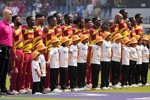 West Indies players stand up for the national anthems before the start of the match during the T20 World Cup cricket match between Nepal and West Indies in Mumbai.