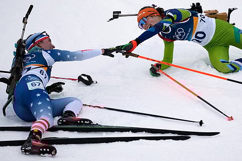 Lucinda Anderson, of the United States, left, reaches out to Lena Repinc, of Slovenia, after the women's 7.5-kilometer sprint biathlon race at the 2026 Winter Olympics in Anterselva, Italy.