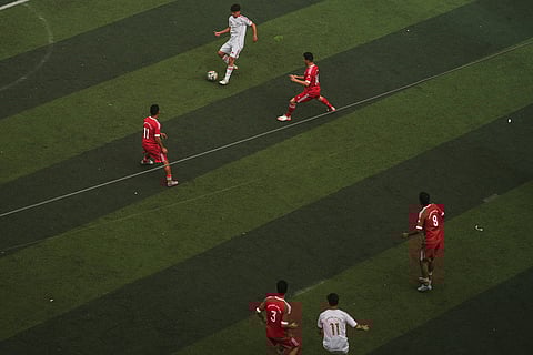 Palestinian players of Gaza Sports Club, top center, and Al-Ahly Club, vie for the ball during a soccer match at a newly constructed field surrounded by buildings destroyed in Israeli ground and air operations, in Gaza City.