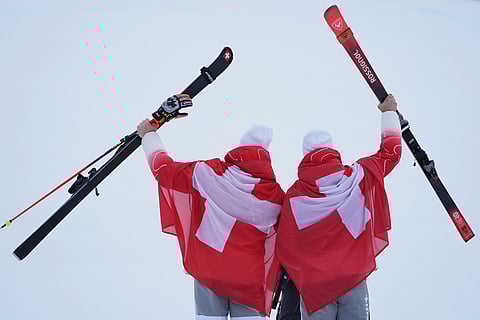 Silver medalist Switzerland's Marco Odermatt, left, and bronze medalist Switzerland's Loic Meillard show their medals for an alpine ski, men's giant slalom race, at the 2026 Winter Olympics, in Bormio, Italy.