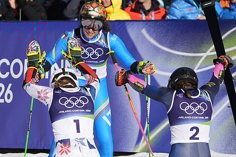 Sweden's Sara Hector, right, and Norway's Thea Louise Stjernesund bow to Italy's Federica Brignone, center, at the finish area of an alpine ski, women's giant slalom race, at the 2026 Winter Olympics, in Cortina d'Ampezzo, Italy.