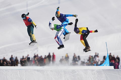 From left, Australia's Adam Lambert (2-1), France's Aidan Chollet (3-1), Italy's Lorenzo Sommariva (6-1) and Germany's Leon Ulbricht (7-1) compete during the mixed team snowboard cross finals at the 2026 Winter Olympics, in Livigno, Italy.