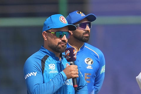Afghanistan's captain Rashid Khan, talks as United Arab Emirates' captain Muhammad Waseem looks on during the toss before the start of their T20 World Cup cricket match in New Delhi.