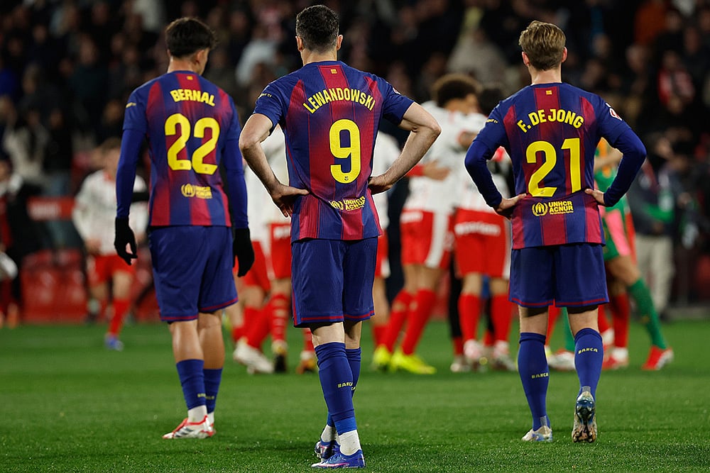 Barcelona's Frenkie de Jong, Marc Bernal and Robert Lewandowski react as Girona player celebrate after winning a Spanish La Liga soccer match between Girona and Barcelona in Girona, Spain. - | Photo: AP/Joan MonfortJoan Monfort