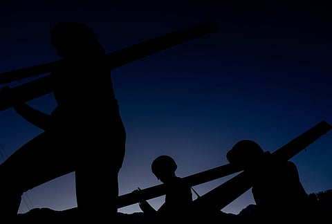 Athletes make their way to the ramp for their trial jump of the ski jumping men's super team competition at the 2026 Winter Olympics, in Predazzo, Italy.