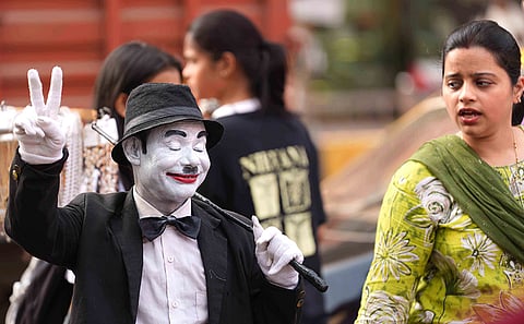 Dressed as Charlie Chaplin, Afsar Khan greets a passerby with a warm handshake in the busy streets of Dadar, sharing a moment of joy amid the rush of Mumbai.