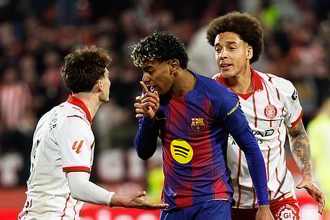 Barcelona's Lamine Yamal argues with Girona's Joel Roca during a Spanish La Liga soccer match between Girona and Barcelona in Girona, Spain.