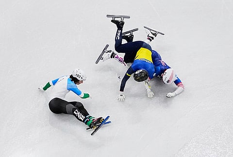 Brandon Kim of the United States, Oleh Handei of Ukraine and Daniil Eybog of Uzbekistan crash in the heats during the men's 500 meter short track speed skating at the 2026 Winter Olympics, in Milan, Italy.