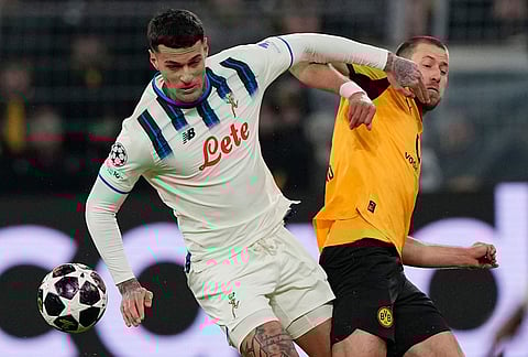 Atalanta's Gianluca Scamacca, left, and Dortmund's Waldemar Anton fight for the ball during the Champions League knockout playoff first leg soccer match between Borussia Dortmund and Atalanta in Dortmund, Germany.