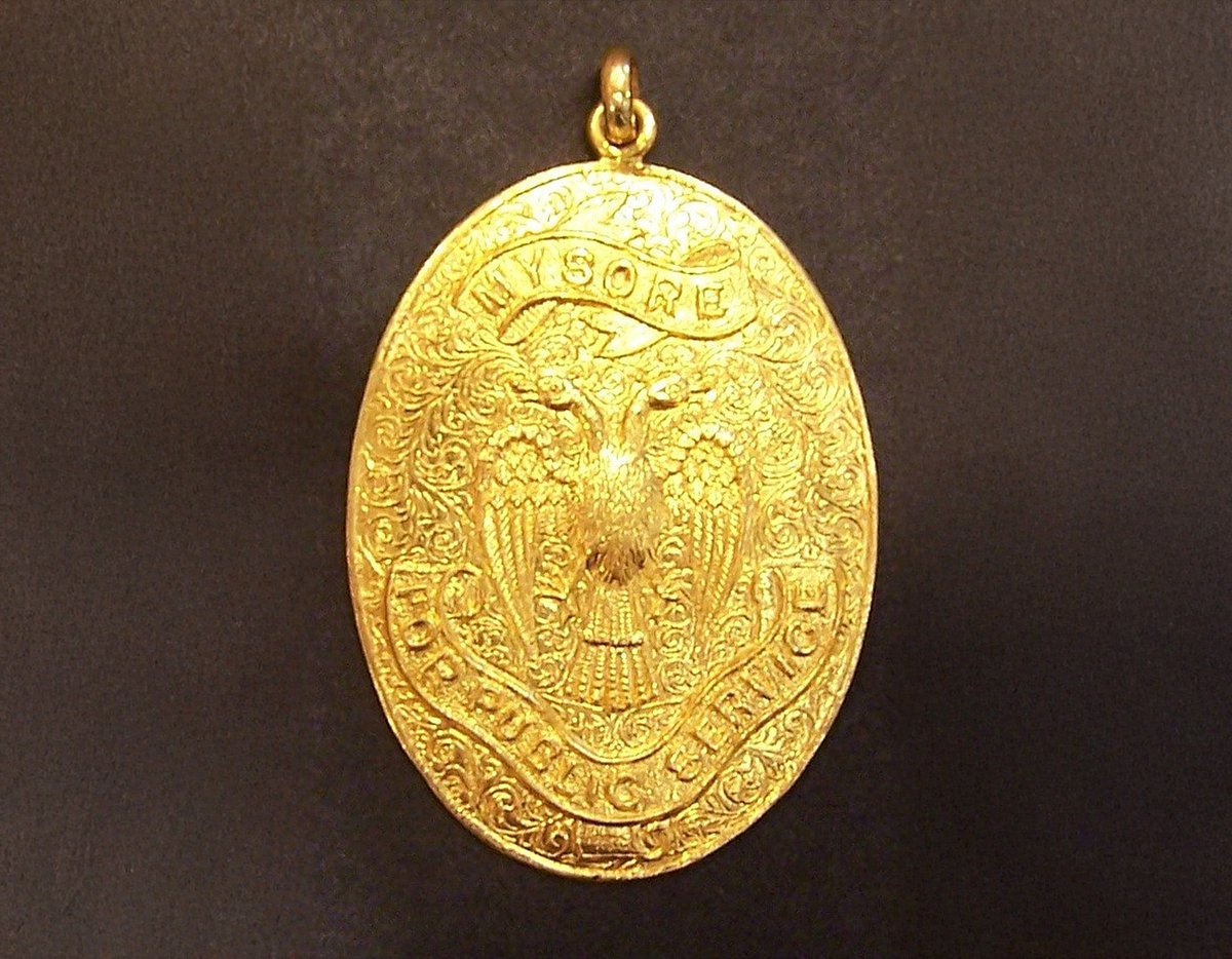 Gold oval medallion engraved with eagle.