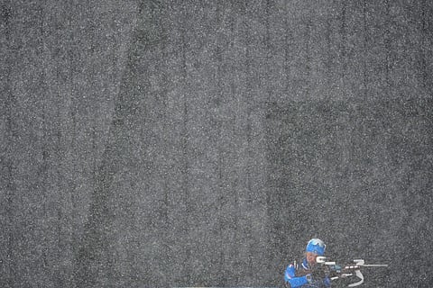 An Italian athlete trains before the men's 4 x 7.5km biathlon relay as heavy snow falls at the 2026 Winter Olympics, in Anterselva, Italy.