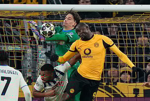 Atalanta's goalkeeper Marco Carnesecchi and Dortmund's Serhou Guirassy go for the ball during the Champions League knockout playoff first leg soccer match between Borussia Dortmund and Atalanta in Dortmund, Germany.
