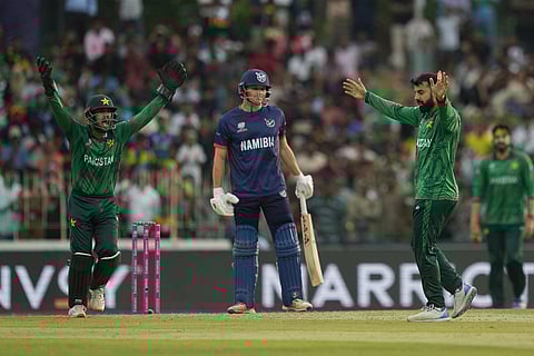Pakistan's Shadab Khan, right, celebrates the wicket of Namibia's captain Gerhard Erasmus, centre, during the T20 World Cup cricket match between Namibia and Pakistan in Colombo, Sri Lanka.