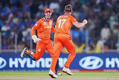 Netherlands' Logan van Beek, right, celebrates with captain Scott Edwards the wicket of India's Tilak Varma during the T20 World Cup cricket match between India and Netherlands in Ahmedabad.