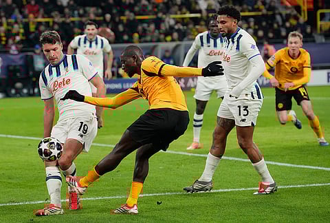 Atalanta's Berat Djimsiti, blocks the shot by Dortmund's Serhou Guirassy during the Champions League knockout playoff first leg soccer match between Borussia Dortmund and Atalanta in Dortmund, Germany.