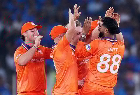 Netherlands' Aryan Dutt, right with back to the camera, is congratulated by teammates for taking the wicket of India's Ishan Kishan during the T20 World Cup cricket match between India and Netherlands in Ahmedabad.