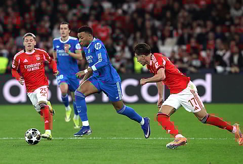 Real Madrid's Kylian Mbappe fights for the ball against Benfica's Amar Dedic and Gianluca Prestianni during a Champions League opening phase soccer match between SL Benfica and Real Madrid in Lisbon, Portugal.