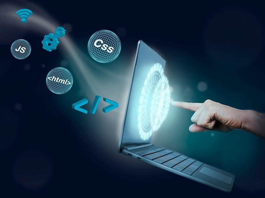 A hand pointing at a glowing digital globe emerging from a laptop screen with floating code icons.