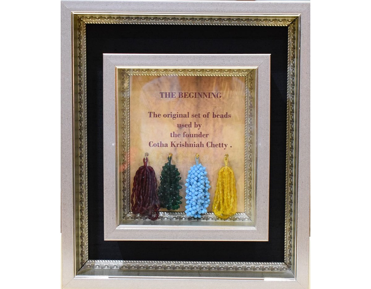 Framed display of colorful bead sets with “The Beginning” title text