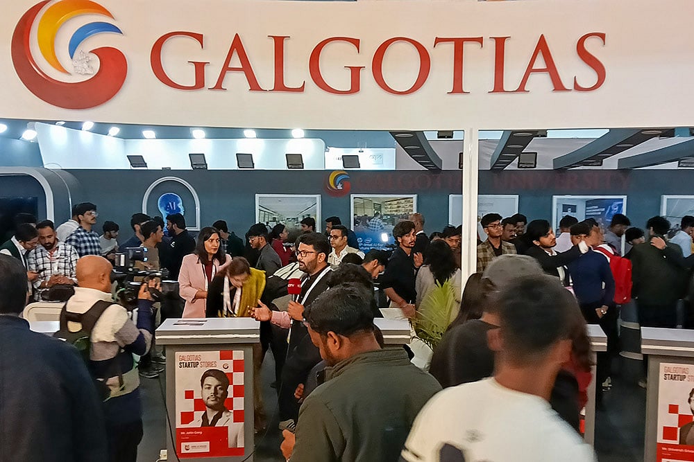 Visitors at Galgotias University's stall during the India AI Impact Summit 2026, in New Delhi. The University has been asked to vacate its stall at the AI Summit Expo immediately, sources said on Wednesday, amid a controversy over the display of a robotic dog that raised questions about the origin and ownership of the technology showcased. - | Photo: PTI
