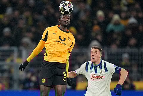 Dortmund's Serhou Guirassy heads the baaa above Atalanta's Mario Pasalic during the Champions League Knockout playoff 1st leg soccer match between Borussia Dortmund and Atalanta in Dortmund, Germany.