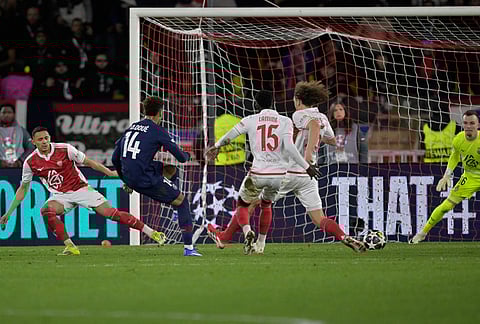 PSG's Desire Doue, second left, scores his side's third goal during the first-leg of the Champions League playoff soccer match between Monaco and Paris Saint-Germain in Monaco.