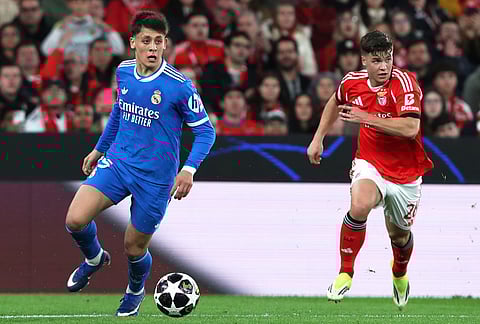 Real Madrid's Arda Guler fights for the ball against Benfica's Samuel Dahl during a Champions League opening phase soccer match between SL Benfica and Real Madrid in Lisbon, Portugal.