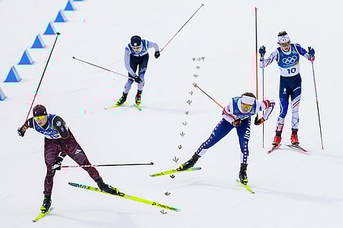 Julian Schmid, of Germany, from left, Ryota Yamamoto, of Japan, Niklas Malacinski, of the United States, and Marco Heinis, of France, approach the finish line in the nordic combined individual Gundersen large hill/10km at the 2026 Winter Olympics, in Tesero, Italy.