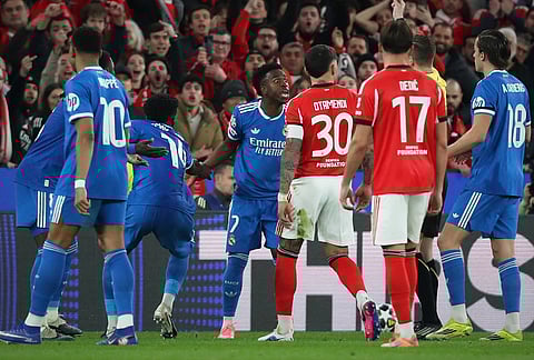 Real Madrid's Vinicius Junior argues with Benfica players after scoring the opening goal during a Champions League playoff soccer match between SL Benfica and Real Madrid in Lisbon, Portugal.