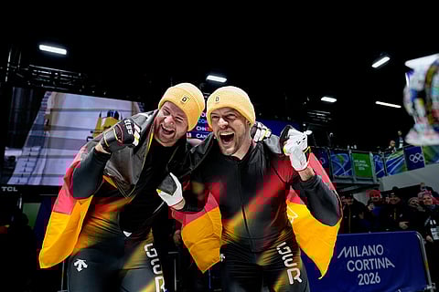 Germany's gold medalists Johannes Lochner, left, and Georg Fleischhauer celebrate at the finish after the two man bobsled competition at the 2026 Winter Olympics, in Cortina d'Ampezzo, Italy.