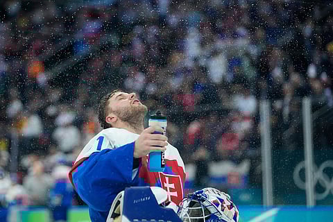 Slovakia's Samuel Hlavaj sprays water during a men's ice hockey quarterfinal game between Slovakia and Germany at the 2026 Winter Olympics, in Milan, Italy.